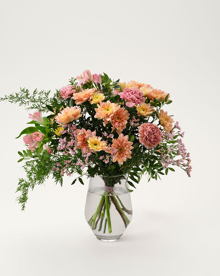 Underbar bukett i fina rosa och aprikosa färgtoner. Blommor: krysantemum, nejlika, alstroemeria, limonium. Plus vippande dekorationsgrönt.
